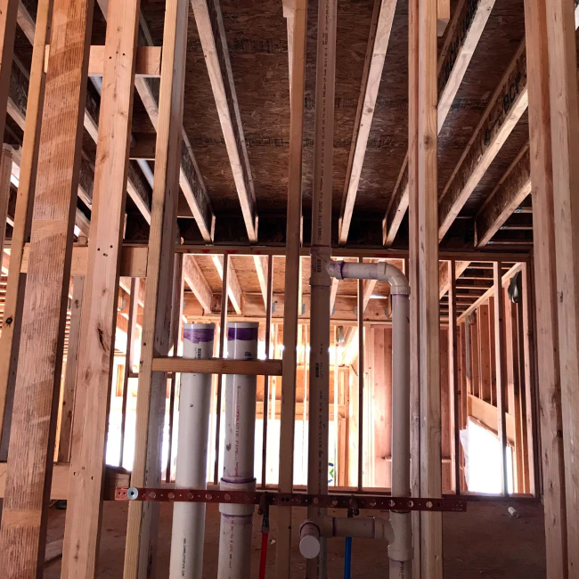 a few pipes installed on a new houses wood frames delta co