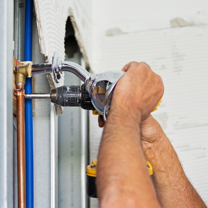 plumber repairing wall plumbing system at building crawford co